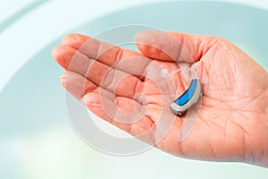 Hand holding hearing aid