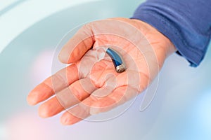 Hand holding hearing aid