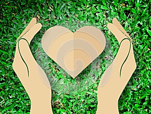 Hand holding heart love the nature symbol Grass background