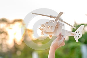 Hand holding helicopter wooden plane toy