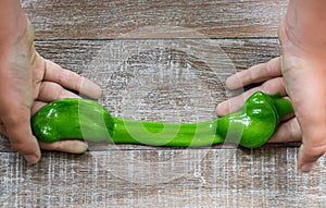 Hand holding homemade green slime.