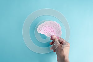 Hand holding human brain paper cut, idea creative intelligence thinking