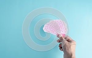 Hand holding human brain paper cut, idea creative intelligence thinking