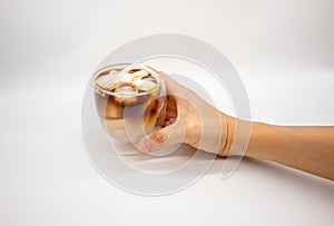 Hand holding iced coconut coffee in double walls glass isolated on white background