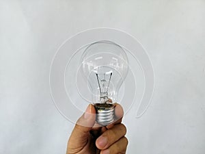 The hand is holding incandescent light bulb, incandescent lamp, incandescent light globe