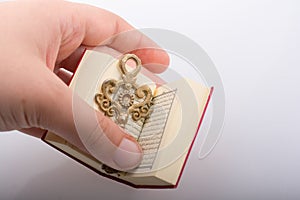 Hand holding Key and Islamic Holy Book Quran