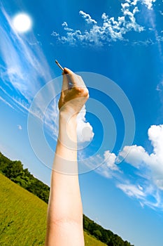 Hand holding keys, blue skies in the background