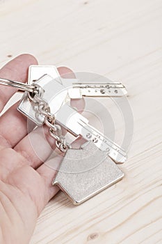 Hand holding keys with house shaped keyring