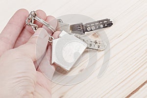 Hand holding keys with house shaped keyring