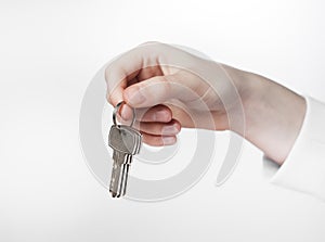 Hand holding keys on keyring over white background