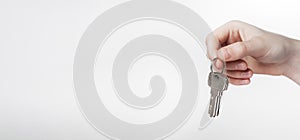 Hand holding keys on keyring over white background. Promo banner for real estate advertising with copy space for text