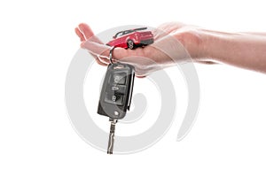 Hand holding keys and red car toy isolated on the white
