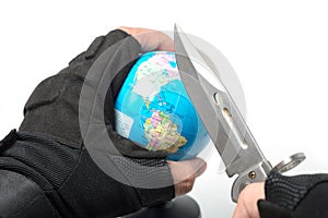 Hand holding knife ready to stab globe world map