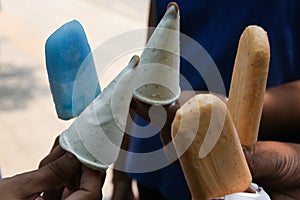 Hand holding kulfi and ice cream stick Delhi India