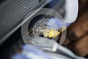 Hand holding a LAN cable to the hub