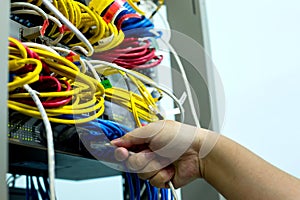 A hand holding LAN cord with Ethernet cables and Network switching hub LAN System Communication