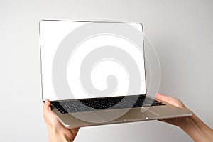 Hand holding laptop with blank screen  on white background