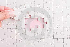 Hand-holding last piece white paper jigsaw puzzle game last pieces