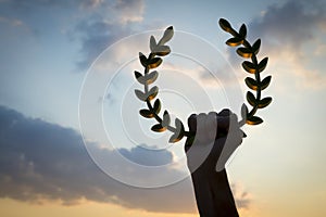 Hand Holding Laurel Wreath Sunset Sky