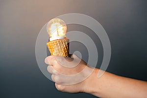 Hand holding led lamp in ice cream cone