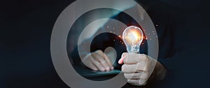 Hand holding light bulb for creative idea concept or innovation, inspiration, innovative of technology in analyzing global