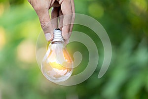 Hand holding light bulb,energy sources for renewable,natural energy concept