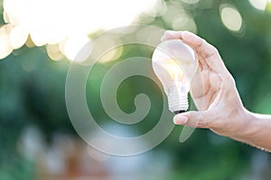 Hand holding light bulb,energy sources for renewable,natural energy