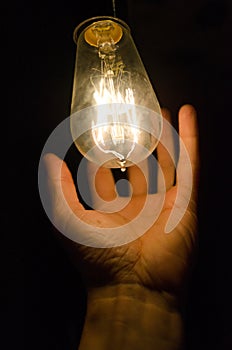 Hand holding a light bulb