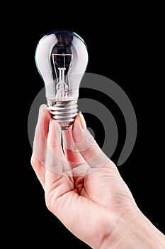 Hand holding light bulb isolated on black