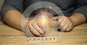 Hand holding a light bulb on word concept. It happens all the time in work, technology, communication, marketing imagination