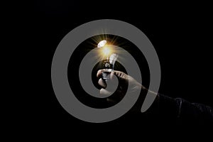 Hand holding lightbulb which it glowing on black background and copy space .Creativity idea concept