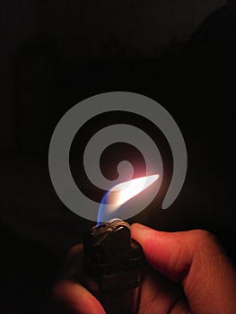 hand holding a lighter in the darkness
