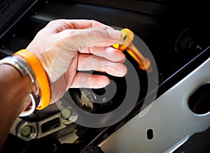 Hand holding lubricant oil level check dipstick