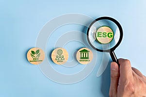 Hand holding magnifying glass focus abbreviation ESG. ESG concept of environmental, social and governance. Sustainable corporation