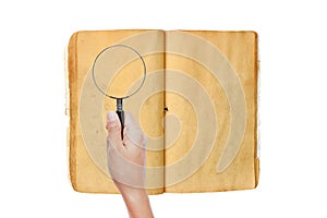 Hand holding Magnifying glass on old book against white background