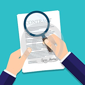 Hand holding magnifying glass over a contract