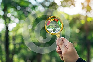 Hand holding a magnifying glass to check the good air quality and clean outdoor air quality safe