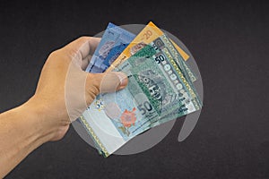 Hand holding Malaysia Ringgit MYR Currency Bank Notes.