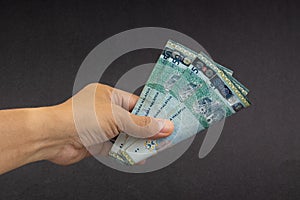 Hand holding Malaysia Ringgit MYR Currency Bank Notes.