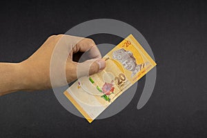 Hand holding Malaysia Ringgit MYR Currency Bank Notes.