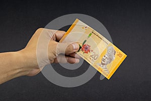 Hand holding Malaysia Ringgit MYR Currency Bank Notes.