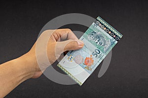 Hand holding Malaysia Ringgit MYR Currency Bank Notes.