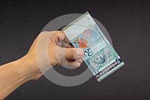 Hand holding Malaysia Ringgit MYR Currency Bank Notes.