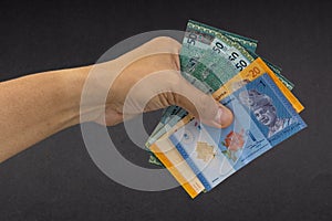 Hand holding Malaysia Ringgit MYR Currency Bank Notes.