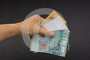 Hand holding Malaysia Ringgit MYR Currency Bank Notes.