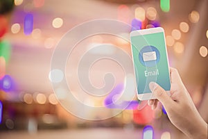 Hand holding man check and sending message with email in a phone on abstract bokeh background