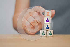 Hand holding manager icon on wood block stack , leadership, brainstorming manpower to success, teamwork and business concept