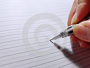 Hand Holding Mechanical Pencil Writing Notes on Notebook
