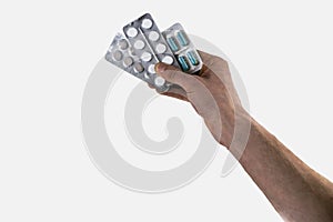 Hand holding medical drugs - full silver leaflet of white pills in common tablets shape, isolated on white background