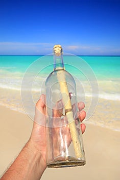 Hand holding message in a bottle